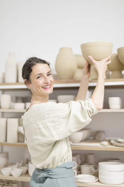 Beautiful ceramist owner looking to the camera while smiling - Φωτογραφία, εικόνα
