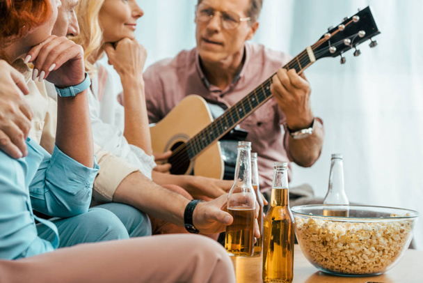 przycięte strzał starych przyjaciół picia piwa i gra gitara akustyczna w domu - Zdjęcie, obraz