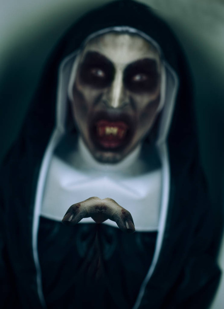 primer plano de una monja malvada aterradora, con dientes ensangrentados, con un hábito típico blanco y negro
 - Foto, imagen