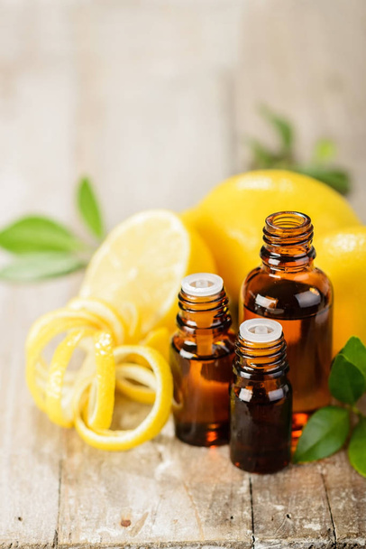 lemon essential oil and lemon fruit on the wooden board, (taken with tilt shift lens) - Φωτογραφία, εικόνα