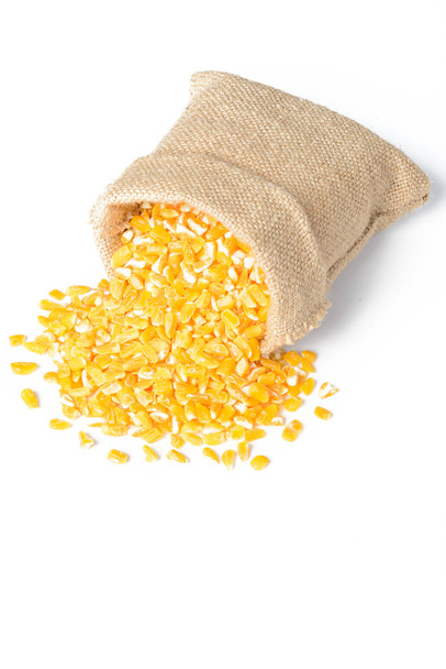 yellow corn grits in sack isolated on white background - Valokuva, kuva