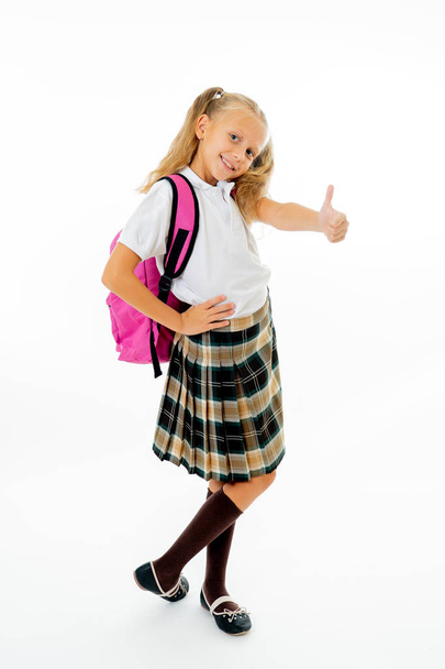 Pretty cute blonde hair girl with a pink schoolbag looking at camera showing thumb up gesture happy to go to school isolated on white background in back to school and children education concept - Photo, image
