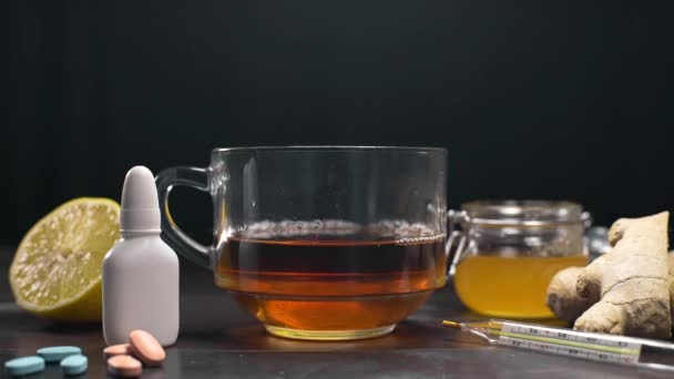 Witaminy czarna herbata z imbirem, cytryny i miodu stoi na stole z pigułki i termometr, naturalne leczenie przeciwko choroby i choroby, złapać zimno, podniesienie odporności - Materiał filmowy, wideo