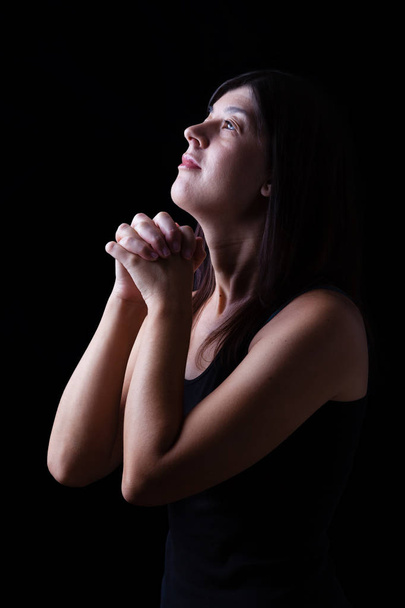 Sadık kadın ibadet umuduyla, elleri katlanmış ve siyah bir zemin üzerine dini şevk ile seyir Tanrı'ya dua. Din, inanç, dua ve maneviyat için kavram. - Fotoğraf, Görsel
