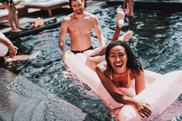 Young Smiling Black Woman having Fun in Pool. Beautiful African Girl in Bikini Enjoying spending time with Friends. Attractive Happy Woman Swimming in Outdoor Hotel Pool. Summer Vacation Concept - Foto, imagen