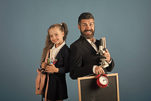 Man with beard and girl in uniform. Teacher and schoolgirl - Photo, Image