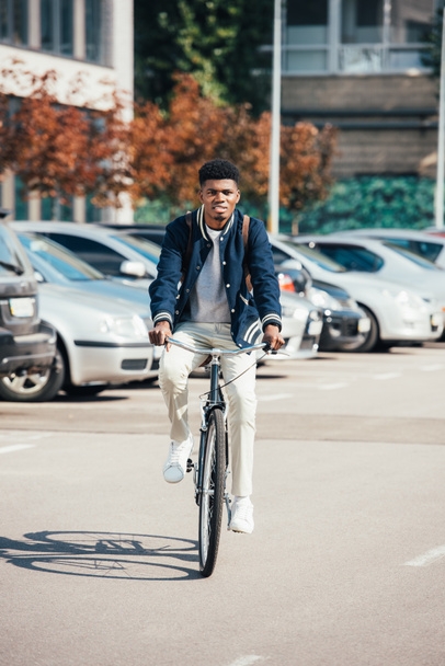 handsome african american man riding trendy bike in city - Valokuva, kuva