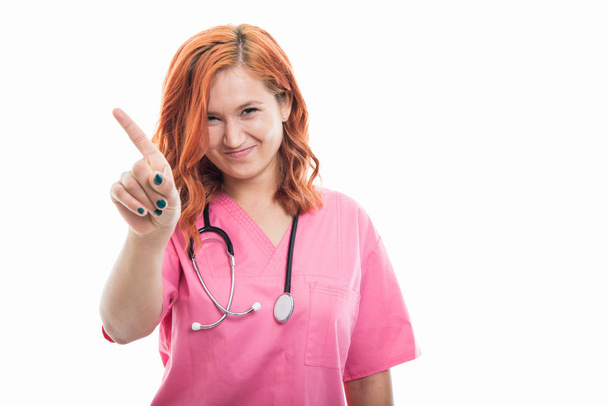 Muotokuva nuori nainen lääkäri stetoskooppi heiluttaa sormella kuin mikään ele eristetty valkoisella pohjalla copyspace mainonta alue
 - Valokuva, kuva
