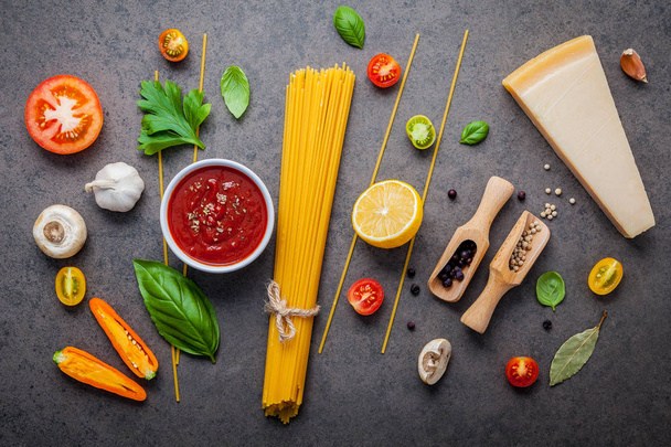 The thin spaghetti on dark stone background. Yellow italian pasta with ingredients. Italian food and menu concept. - Fotografie, Obrázek