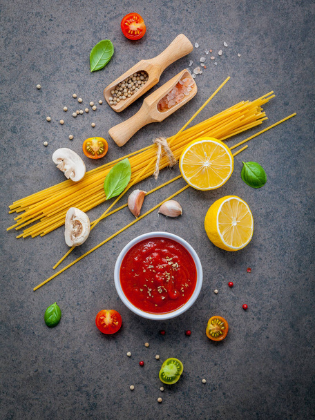 The thin spaghetti on dark stone background. Yellow italian pasta with ingredients. Italian food and menu concept. - Foto, afbeelding