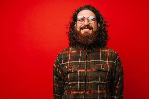 Портрет веселого бородатого чоловіка з довгим волоссям і носити круглі окуляри і посміхаючись
 - Фото, зображення