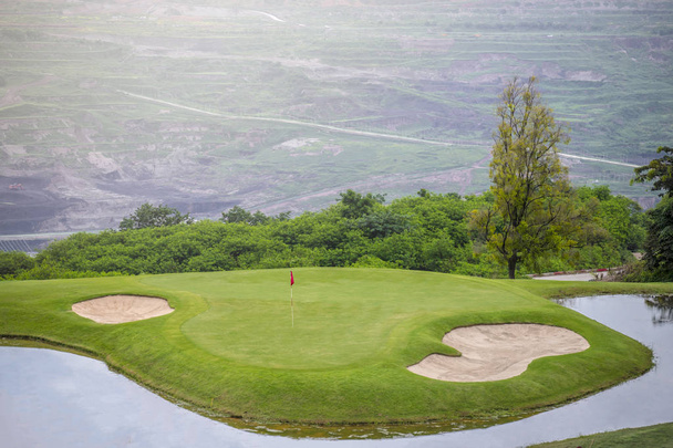 Campo de golf con césped verde y bandera de alfiler rojo
 - Foto, imagen