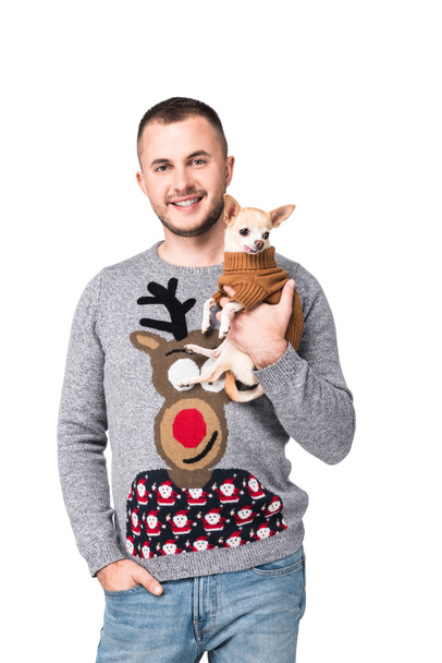 portrait of smiling man in festive winter sweater with little chihuahua dog isolated on white - Photo, image