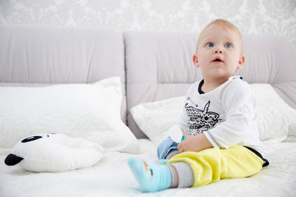 Petit garçon ludique portant un pyjama bleu dans le lit des parents
 - Photo, image