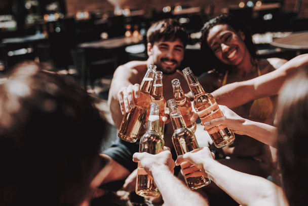 Young Friends with Alcoholic Drinks at Poolside. Group of Young Smiling People holding Bottles of Beer and having Fun at Poolside. Happy Friends Enoying Pool Party. Summer Vacation Concept - Foto, Imagem