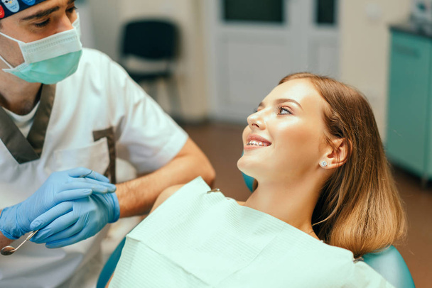 Dentist examine female patient with braces in denal office - Zdjęcie, obraz