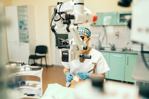 Dentist examine oral cavity of female patient with microscope - Zdjęcie, obraz