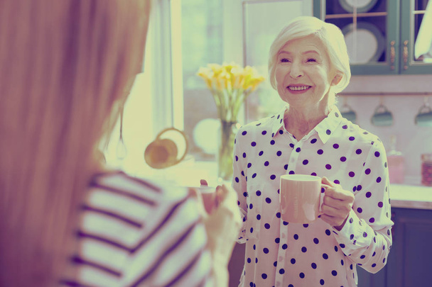 Delighted senior woman spending morning in her kitchen - Photo, Image