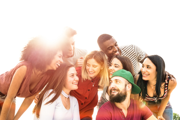 Multiraciale beste vrienden millennials op zoek elkaar met tegenlicht - Happy vriendschap jeugdconcept tegen racisme met internationale jongeren plezier samen - warme pastel filter Toon - Foto, afbeelding