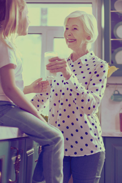 Positive delighted blonde woman holding glass of milk - Foto, Imagem