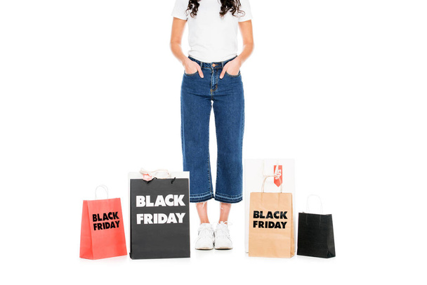 cropped view of woman posing at shopping bags with black friday sale signs isolated on white - Fotoğraf, Görsel