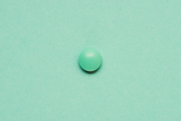 top view of round green tablet on green background  - Foto, afbeelding