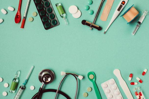 Płaskie układanie różnych pigułek medycznych i instrumentów na zielonym tle  - Zdjęcie, obraz