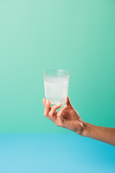 cropped shot of person holding glass with liquid medicine isolated on green - Photo, Image