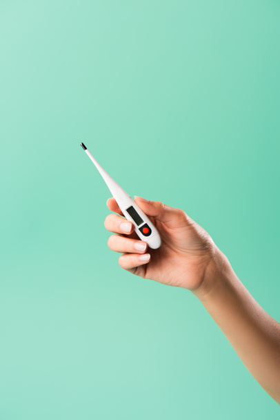 cropped shot of person holding electronic thermometer isolated on green - Fotografie, Obrázek