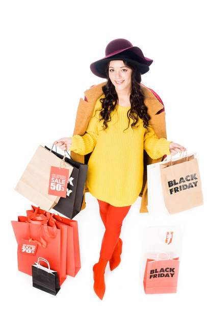 Stilvolles Mädchen mit Kreditkarte und Einkaufstaschen für Black Friday isoliert auf Weiß - Foto, Bild