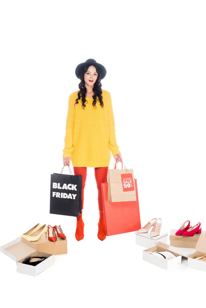 stylish girl holding shopping bags with black friday symbol isolated on white with footwear  - Photo, Image