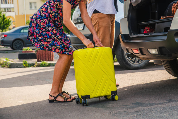 couple put bags in car trunk. road trip concept - Foto, Imagen