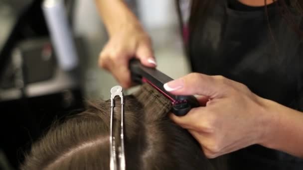 Close-up shot of a woman having her hair straightened in hair salon. Shot in slow motion. hd - Footage, Video