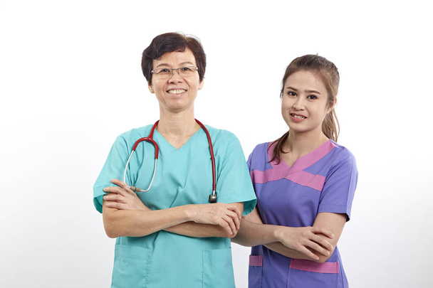 zwei medizinische Person Krankenschwester junge Arzt Porträt selbstbewusst junge Frau Arzt isoliert auf weißem Hintergrund junge hübsche multirassische asiatische kaukasische weibliche Modell - Foto, Bild