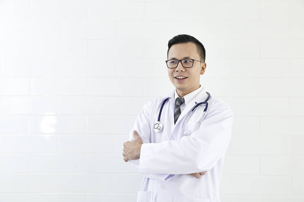 Азіатський чоловічого лікар посміхається з обіймами, що перейшли на грудях портрет, поняття технології комунікації. копія простір. - Фото, зображення