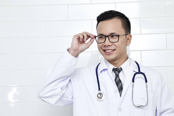 Médico masculino asiático sonriendo con los brazos cruzados en el retrato de pecho, Conceptos de comunicación tecnológica. espacio de copia
. - Foto, Imagen