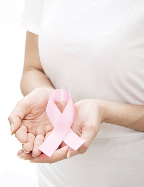 Kobieta ręki trzymającej wstążki świadomości raka piersi różowy. Opieki zdrowotnej i medycyny pojęcie. - Zdjęcie, obraz