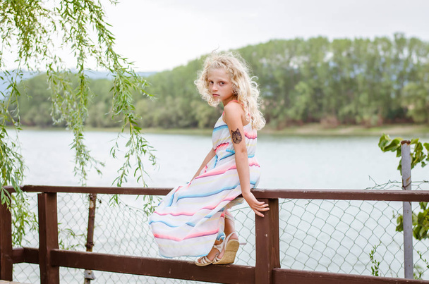 adorable niña en vestido cerca del estanque al aire libre
 - Foto, imagen