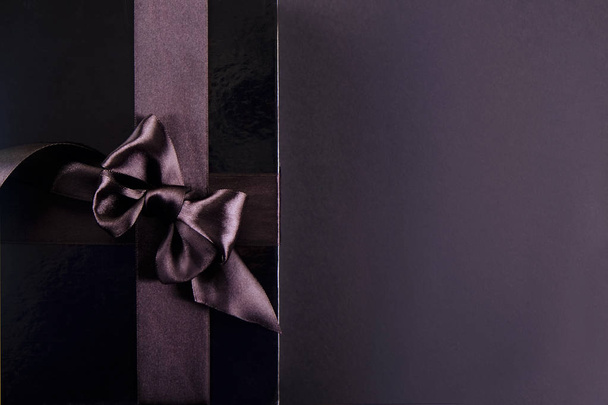 Beautiful minimalistic multi purpose composition with gift box wrapped and tied with satin ribbon. Holiday present in festive wrapping. Background, copy space, close up, top view, flat lay. - Foto, Imagen