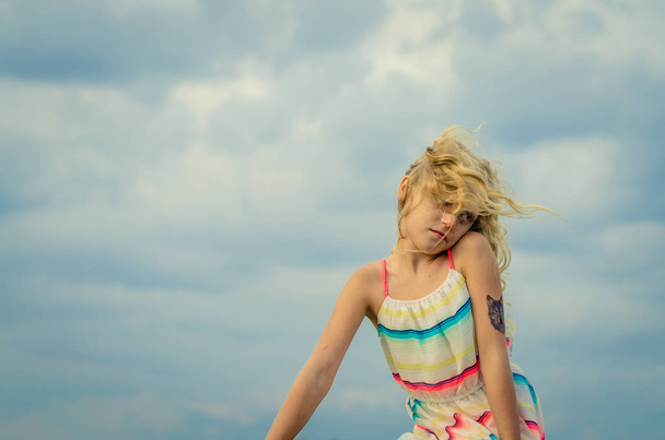 прелестная маленькая девочка с портретом блондинки и голубым небом
 - Фото, изображение