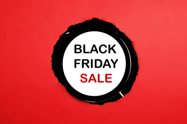Black friday sale concept. Fourth Friday of November, beginning of Christmas shopping season since 1952. Old alarm clock with text inside torn paper hole. Copy space, close up, top view, flat lay. - Photo, image