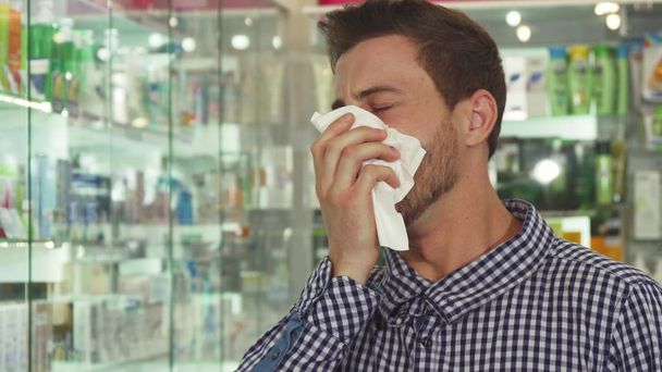 Человек кашляет и чихает в аптеке
 - Фото, изображение