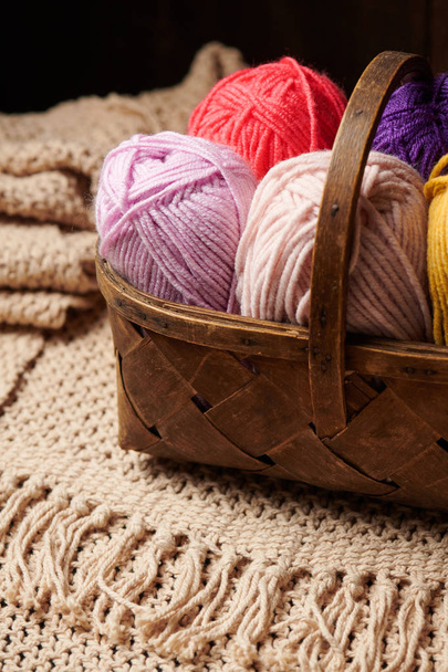 fios de lã coloridos para tricô em cesta, fundo de madeira
 - Foto, Imagem