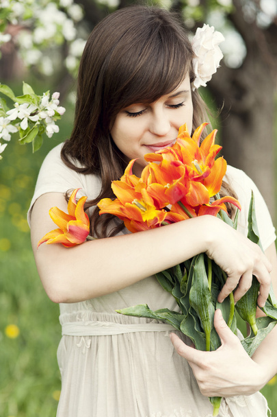 Женщина наслаждается ароматом цветов
 - Фото, изображение