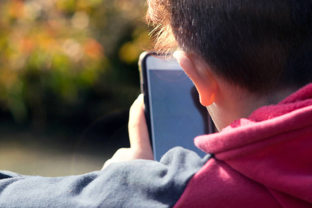 Pre Teen utilisant un smartphone à l'extérieur
 - Photo, image