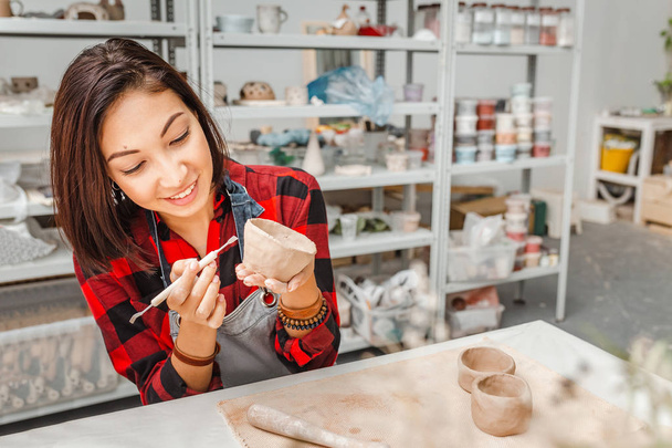 Друзі молодої жінки створюють глиняний та керамічний художній посуд у керамічній майстерні
 - Фото, зображення