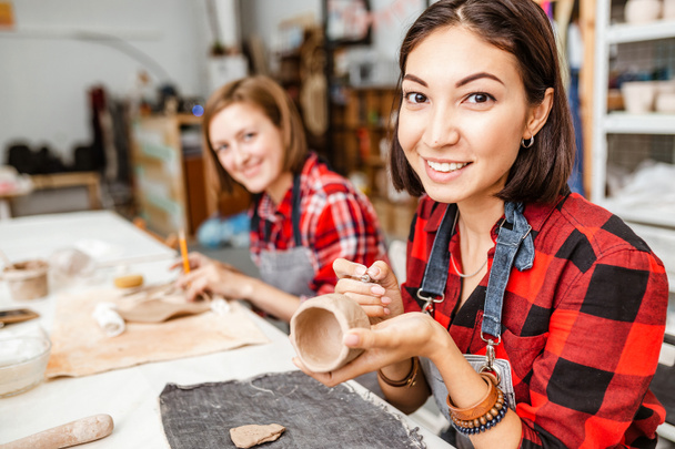 Jóvenes amigas crean platos de arcilla y cerámica en taller de cerámica
 - Foto, Imagen