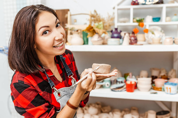 Jonge vrouw vrienden maken klei en keramische kunst gerechten in de pottenbakkerij - Foto, afbeelding