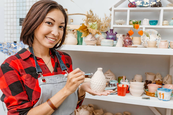 Молодые женщины-друзья создают глиняные и керамические блюда в керамической мастерской
 - Фото, изображение