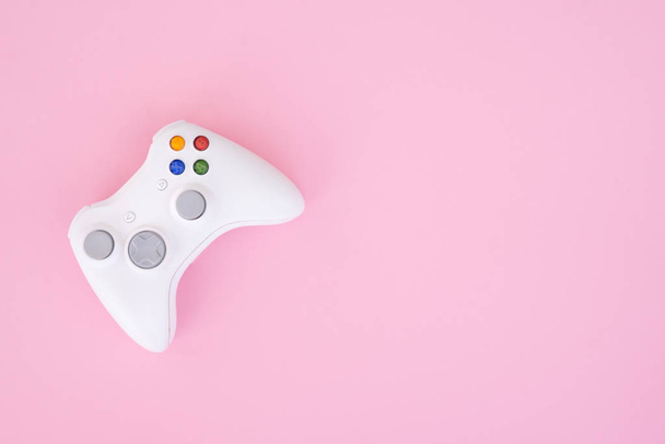 Witte gamepad, controller op een pastel roze achtergrond. Witte joystick is geïsoleerd op een roze achtergrond. Video games competitie. Gaming concept. Copyspace. Flatlay - Foto, afbeelding